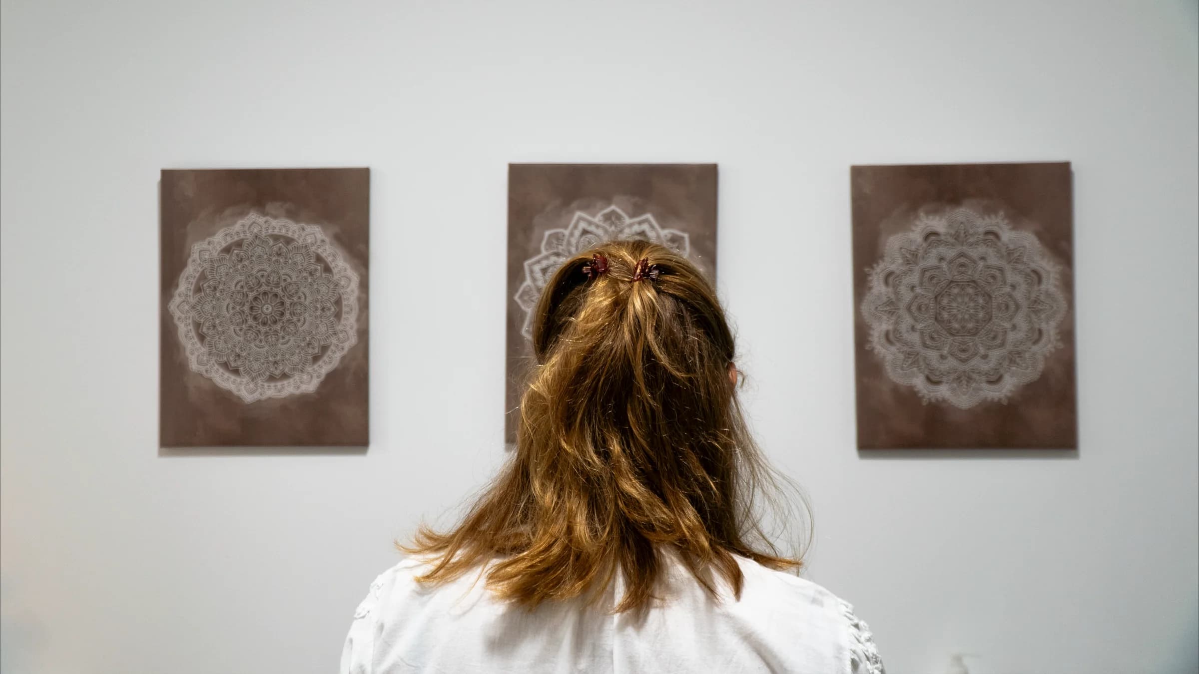 Rosina de espaldas frente a los tres mandalas que presiden la sala de fisioterapia de Bennu Salud